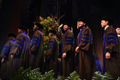2023 PhD graduates process across the stage.