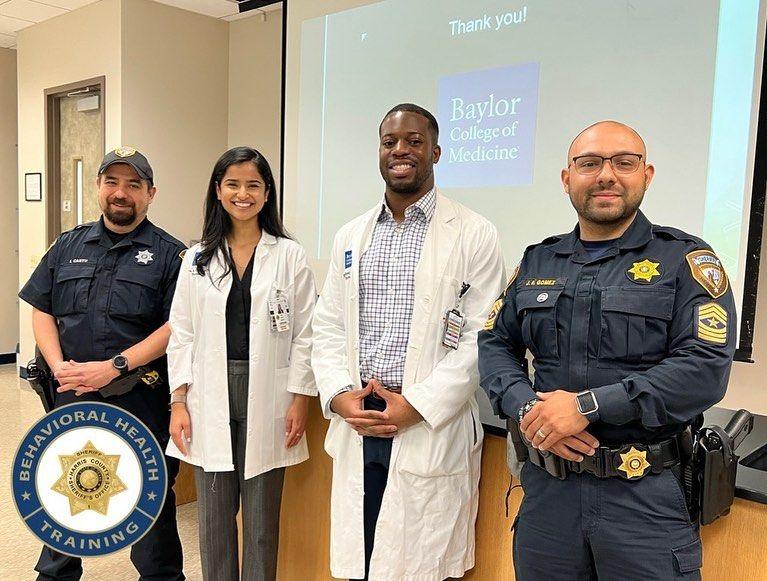 Two police officers and two doctors pose after a presentation.