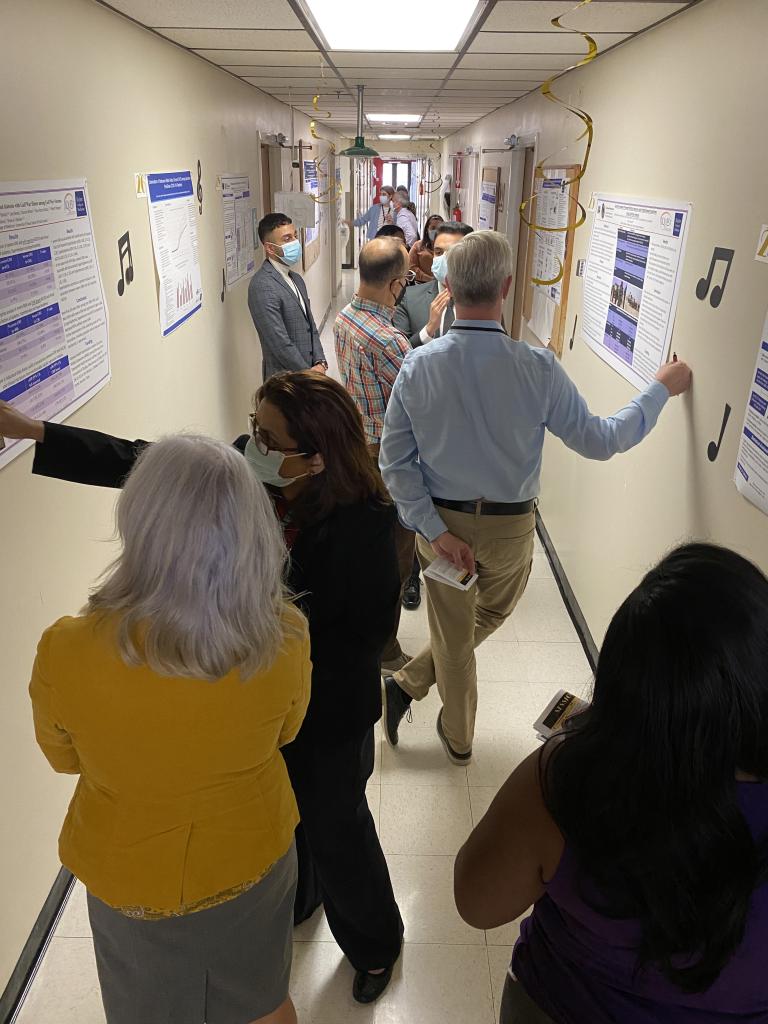 Investigators presenting to judges and other attendees at the 2022 8th Annual MEDVAMC Poster Session, "The Great Poster Session."