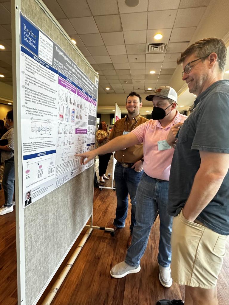Steven Wall presents a poster to conference attendees.