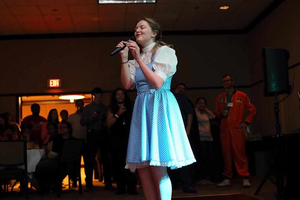 A person dressed as Dorothy from Wizard of Oz singing karaoke