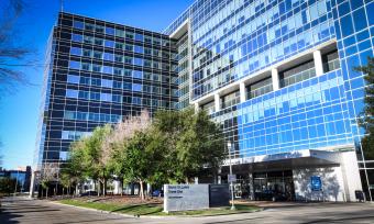 Baylor St. Luke's Tower One, a large windowed building with a blue sky behind it.