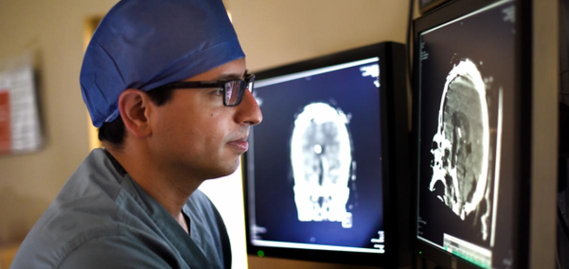 Doctor looking at monitor of brain scans.