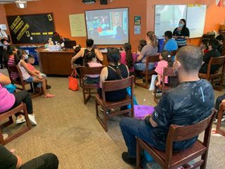 Several people seated in chairs while watching a health informational.