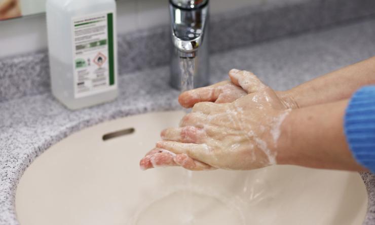 A person washing their hands with soap.