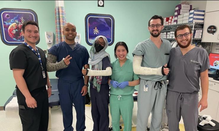 Five orthopedic surgery residents standing in an exam room