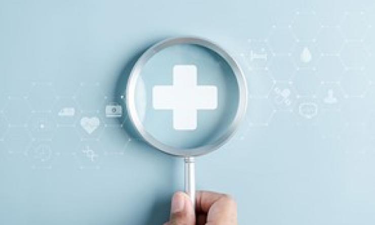 Image of magnifying glass on a health cross