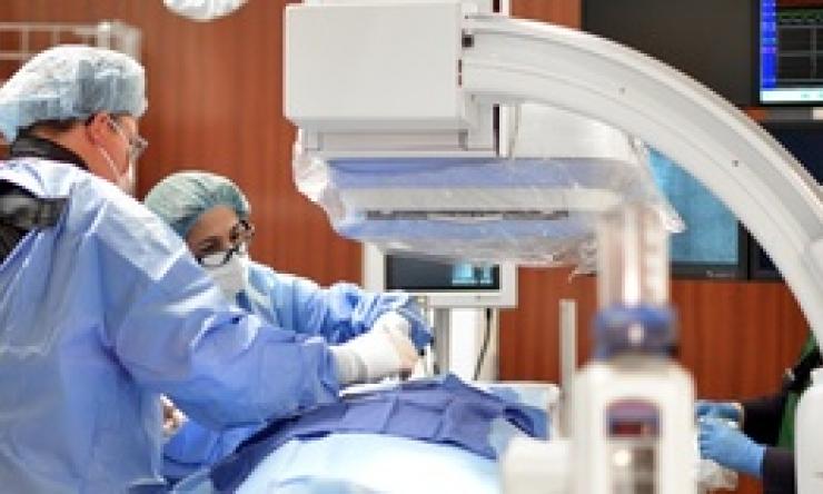 Two doctors are in a surgical setting performing an operation