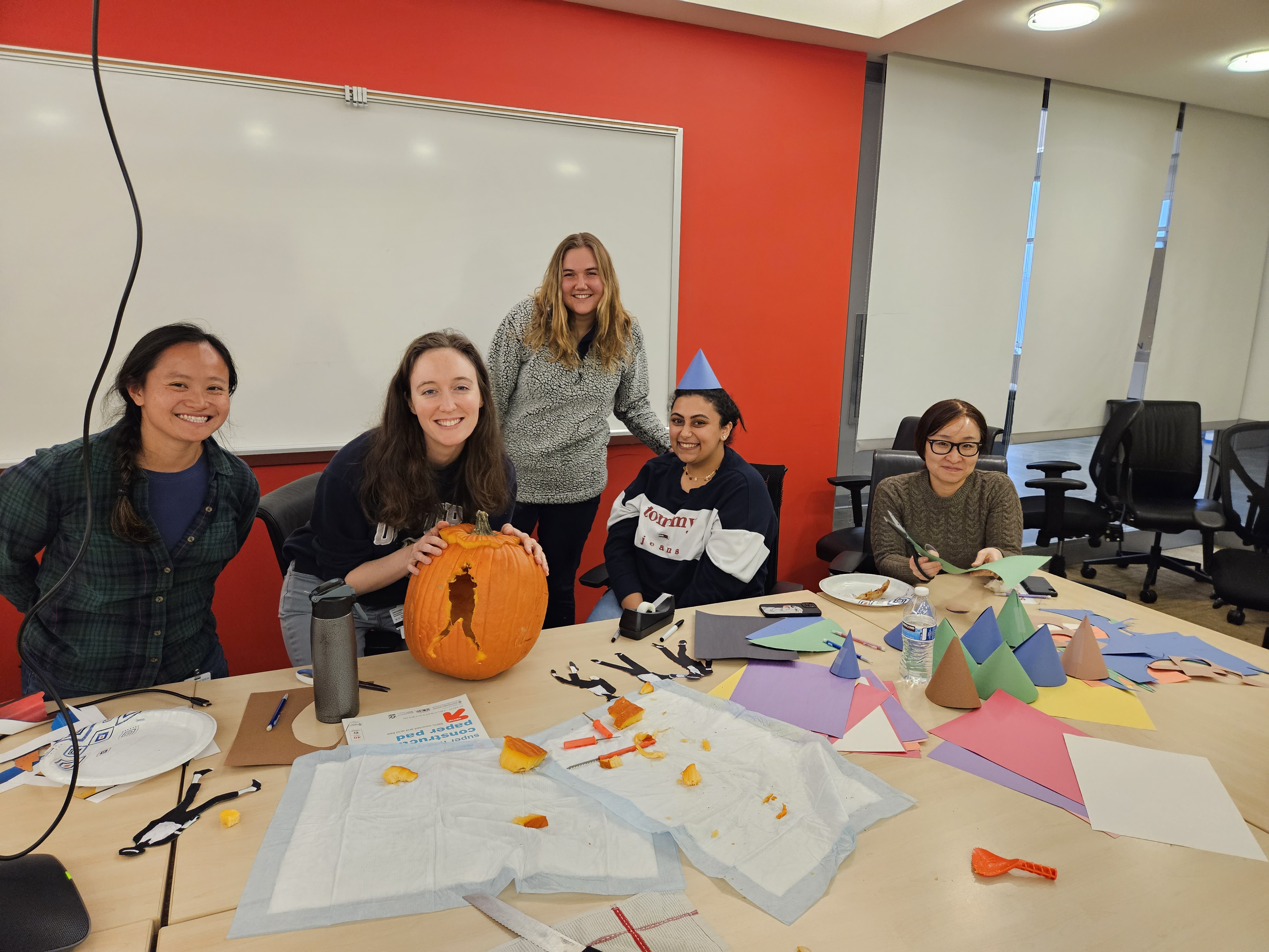 Photo of the Echeverria Lab members carving a pumpkin for Halloween