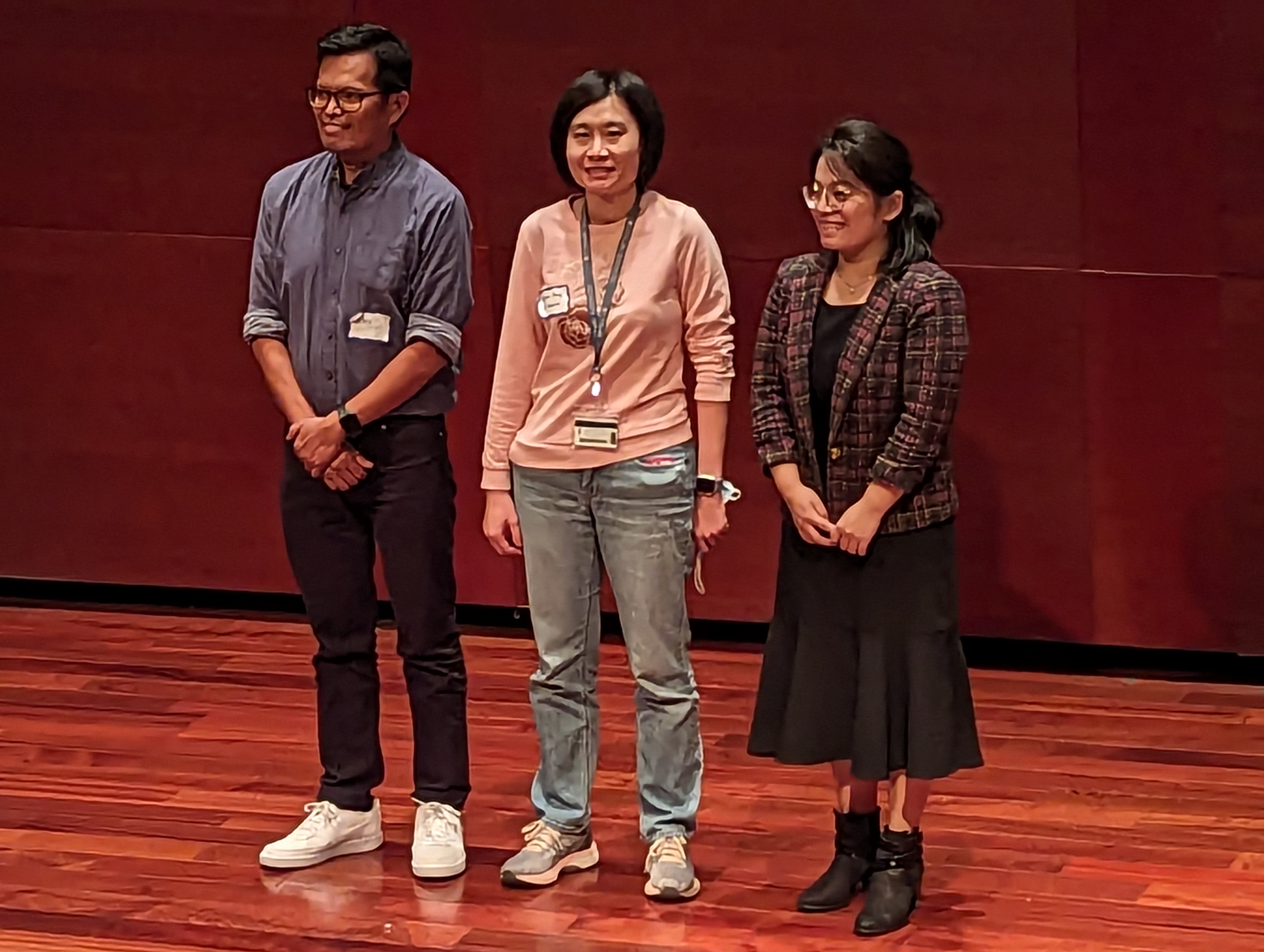 three people standing on a stage