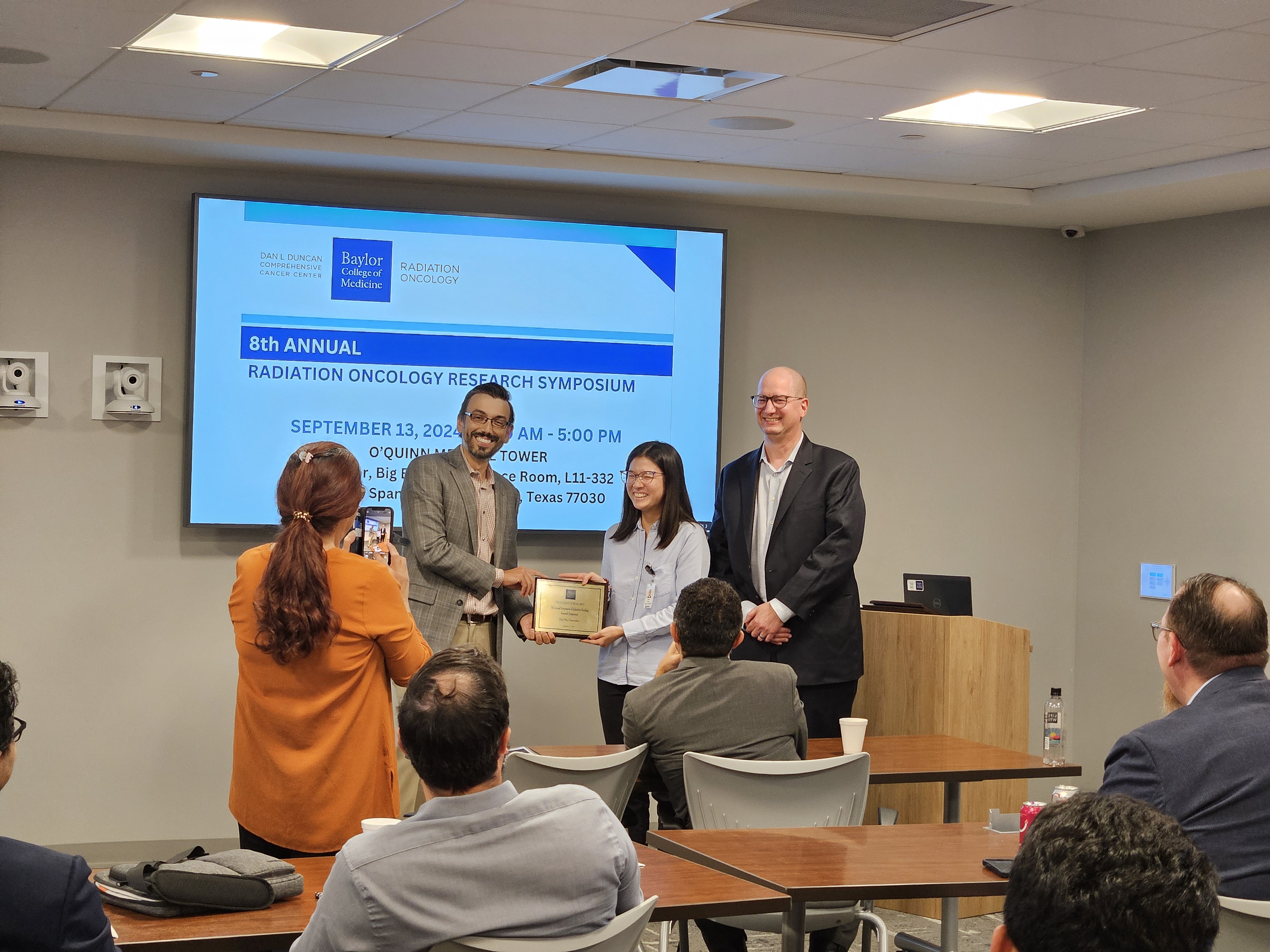 woman giving a presentation, and receiving a plaque