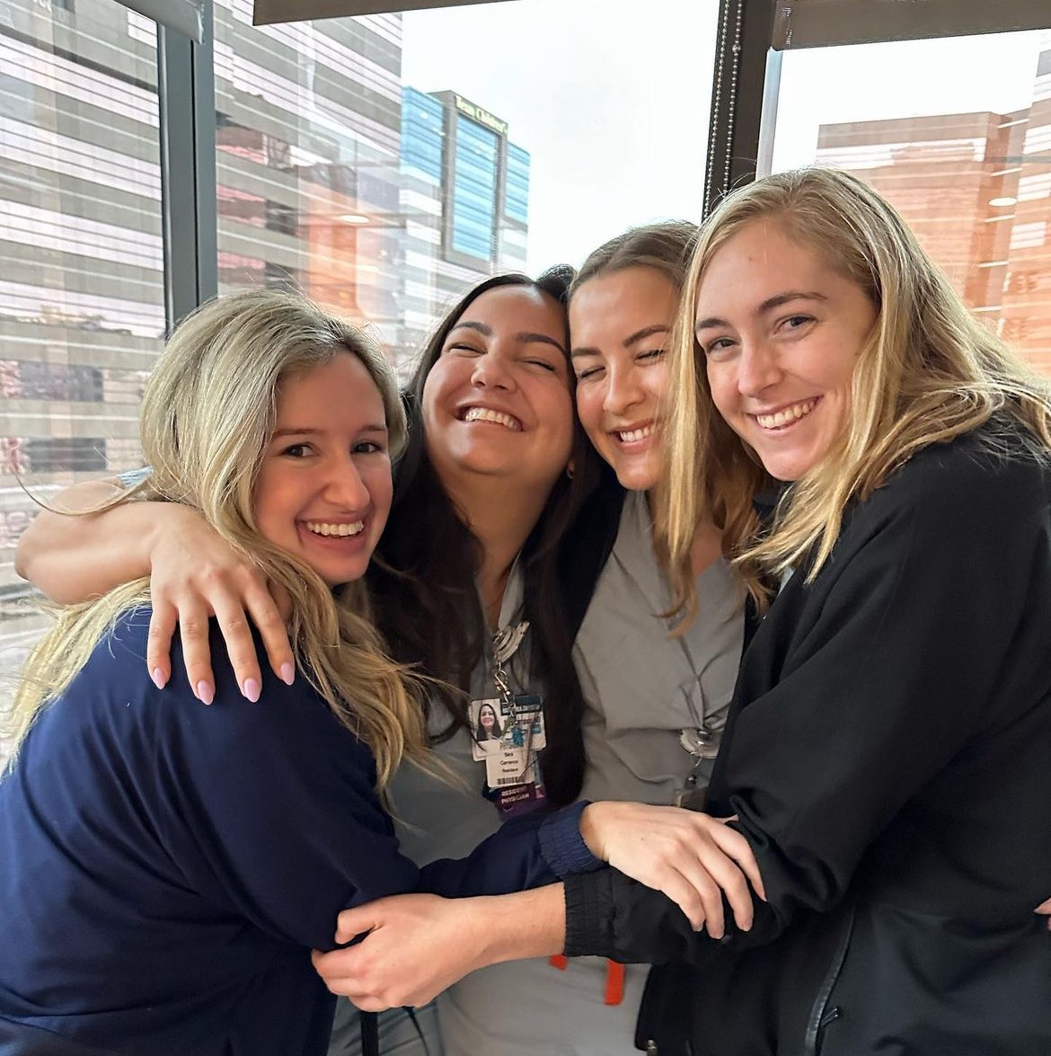 4 women holding each other and smiling