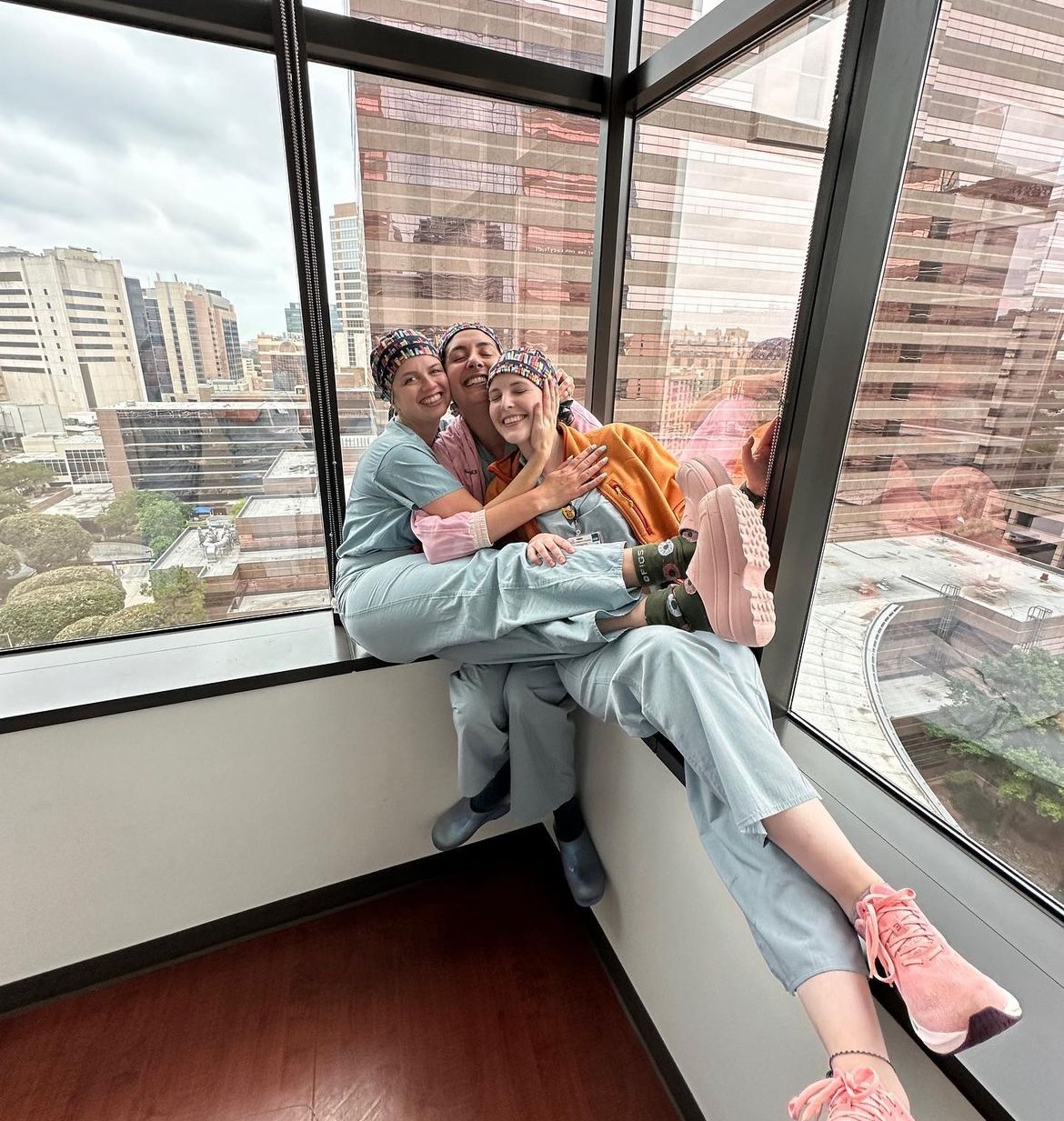 people smiling on indoor window ledge