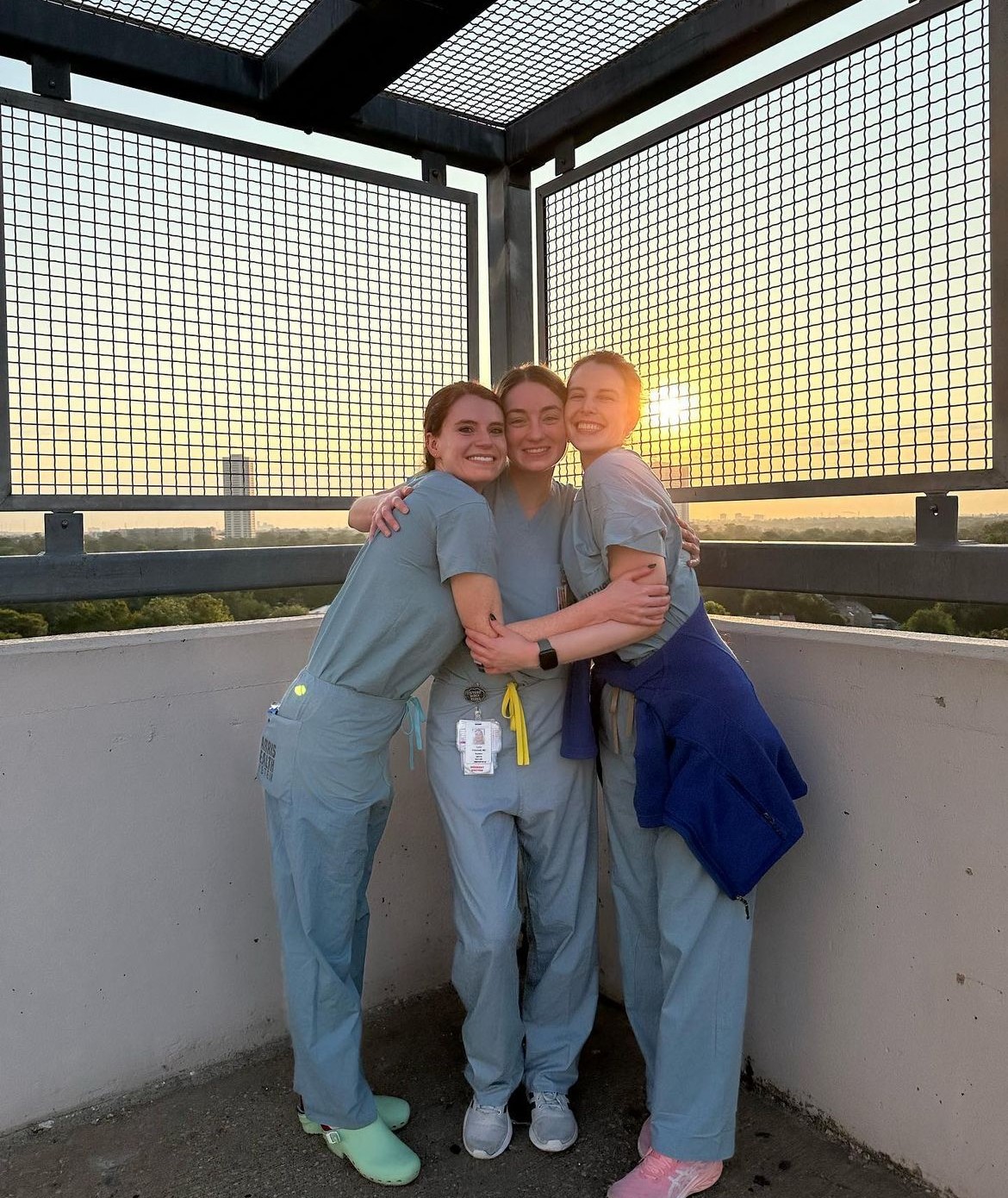 3 ob/gyn residents standing in front of sunset smiling