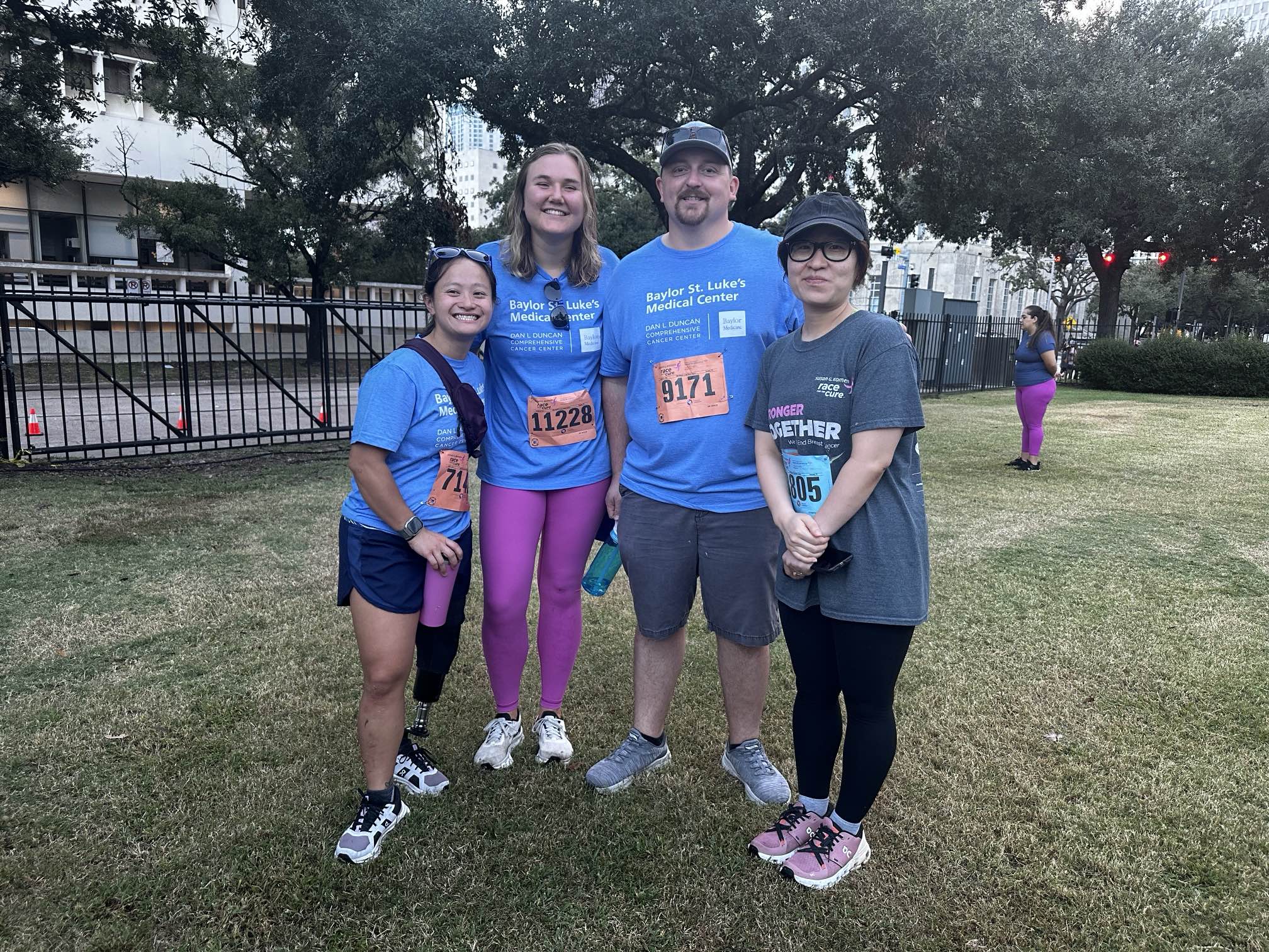 4 people in T-shirts standing in a field