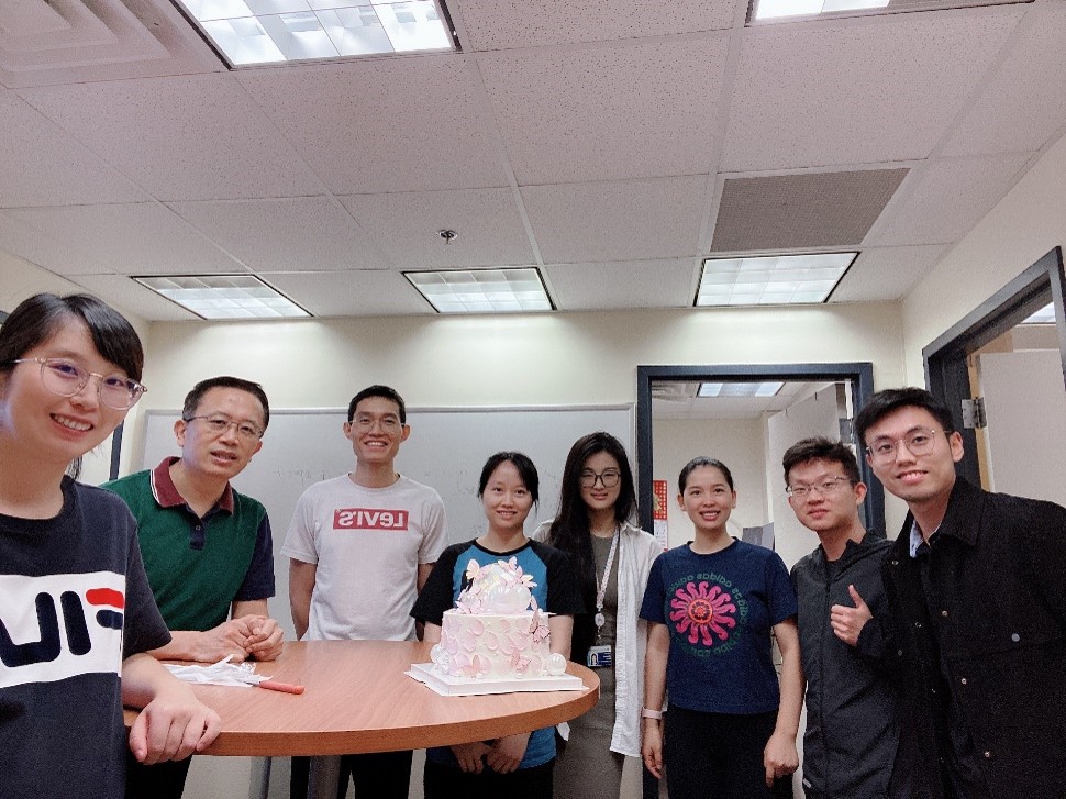 group of people gathered around a birthday cake