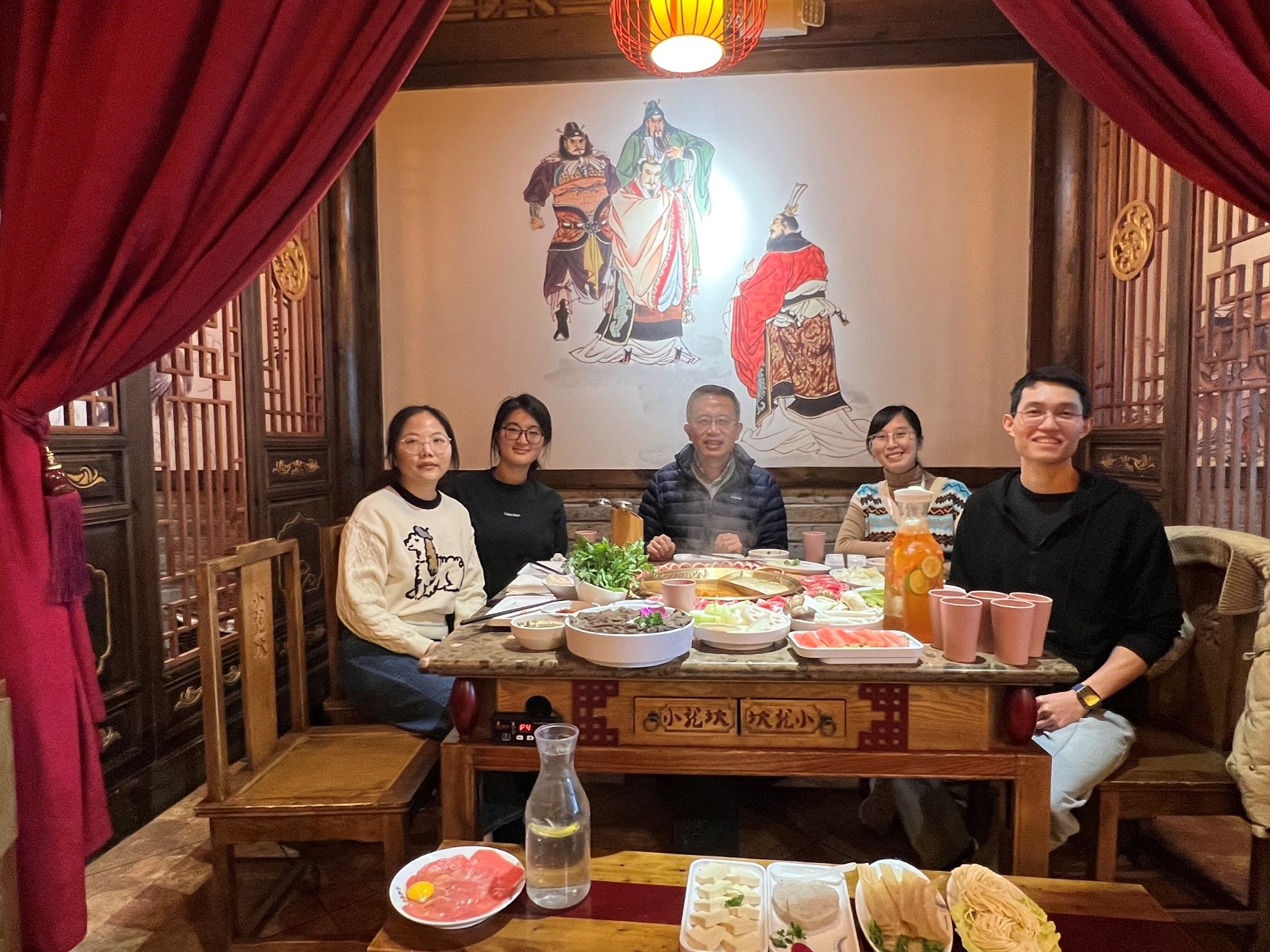 people sitting at a restaurant table with Chinese decor