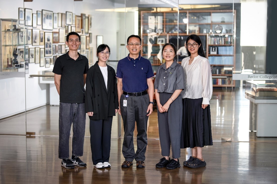 group of people standing in front of a medical display