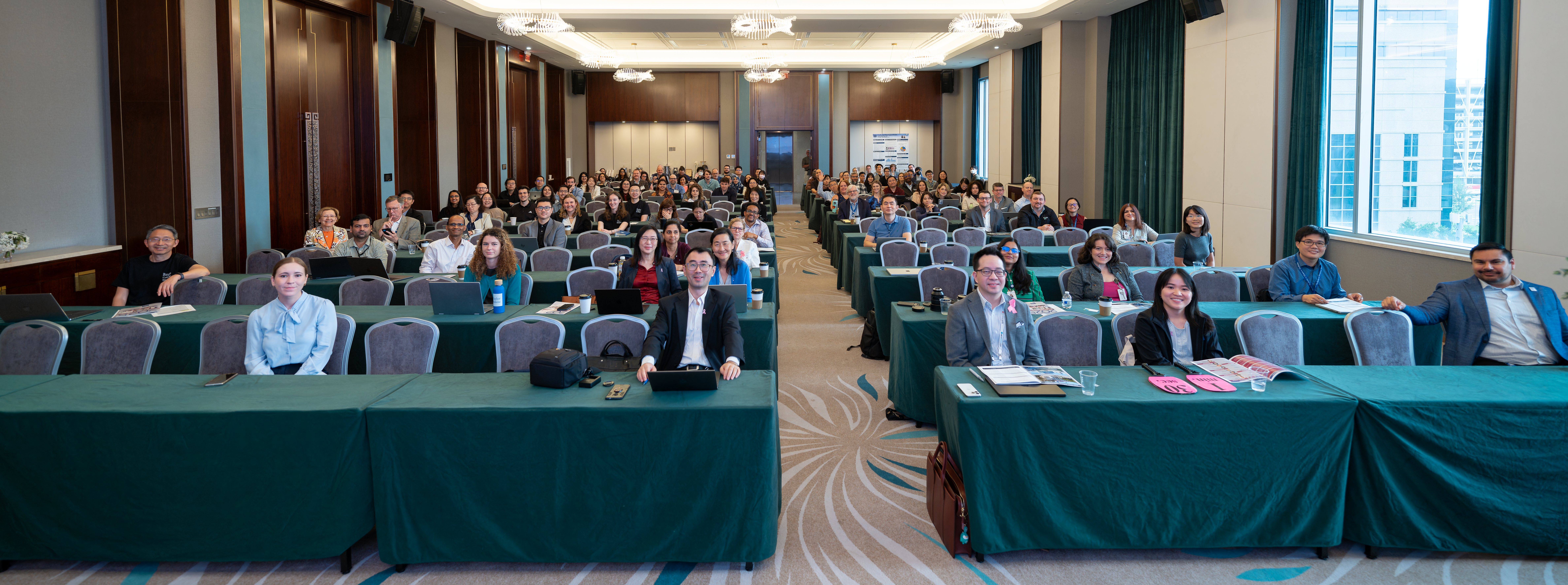 group of people sitting behind tables in a conference room