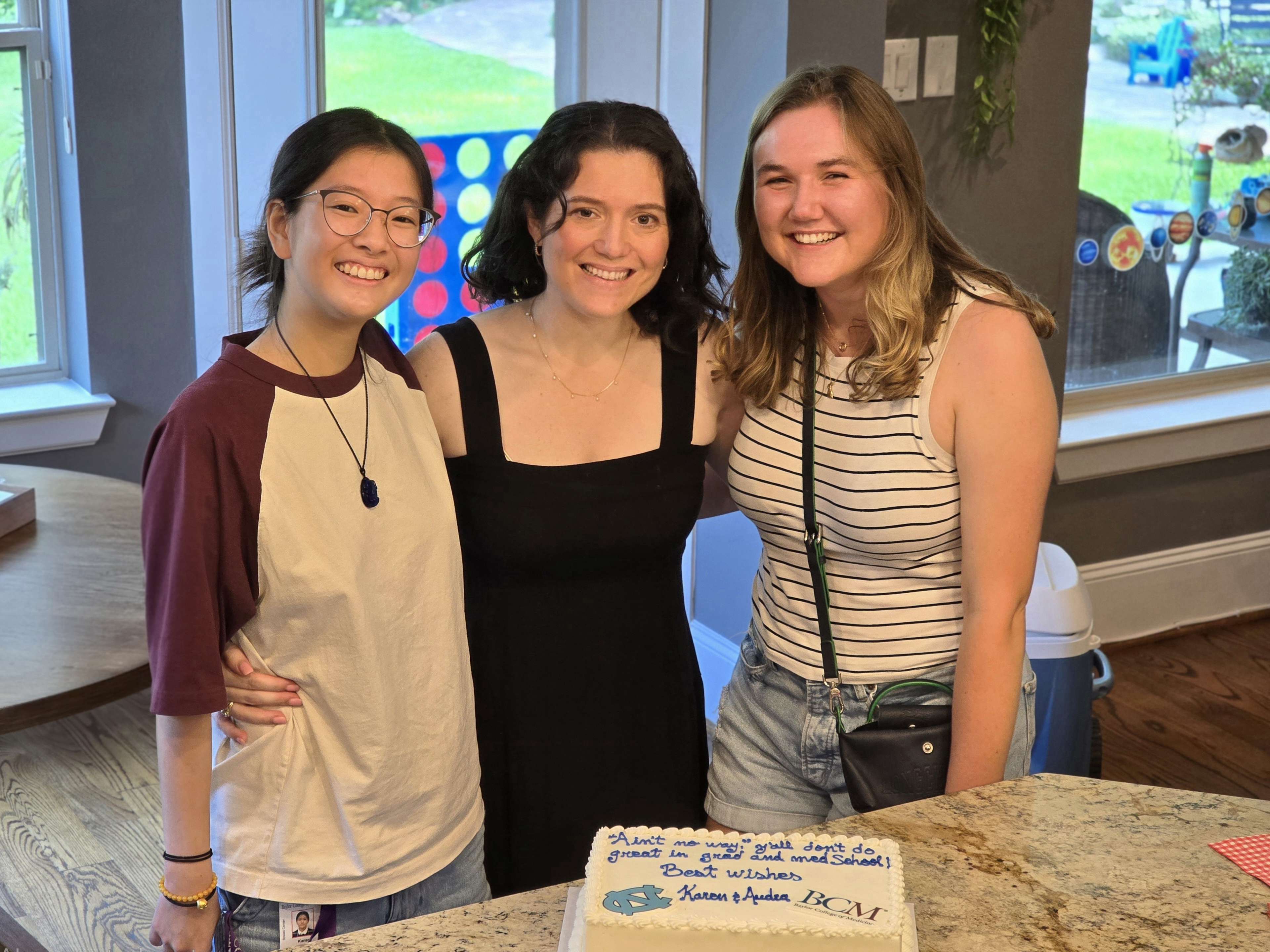 picture of 3 people standing behind a cake on a table
