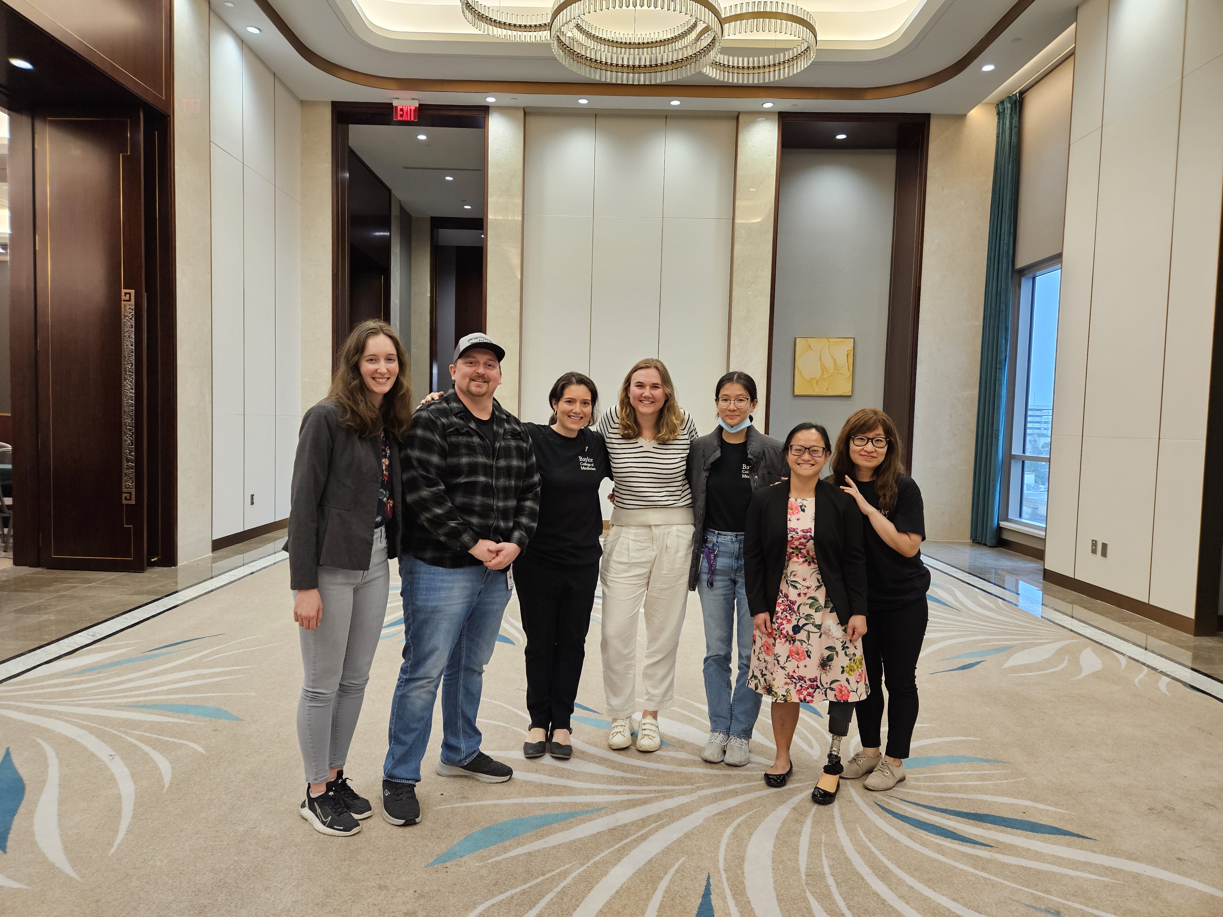 seven people standing in a ballroom
