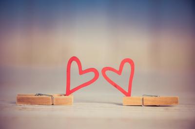 A pair of cartoon hearts held up by clothes pins.