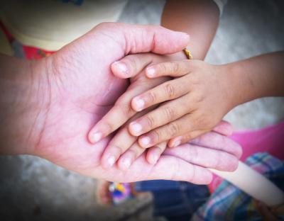 Adult hands holding child's hands