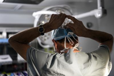 Dr. Marc Moon tying his mask in the OR