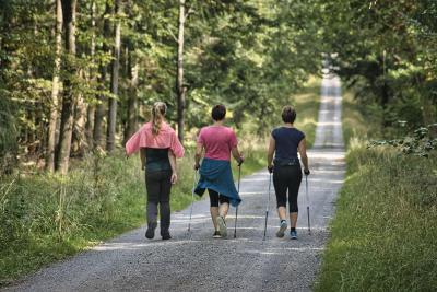 Three women walking on a nature trail. 