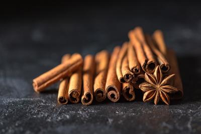 Stack of cinnamon sticks and star anice spice on a black background