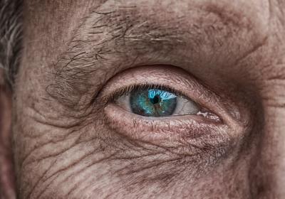 Close up photograph of an elederly man's blue eye.