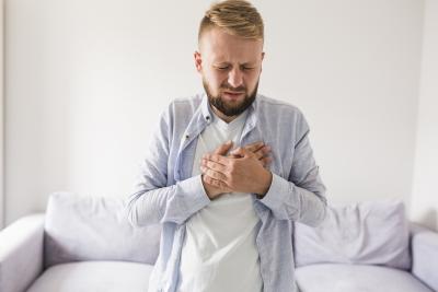 Man standing holding his chest in pain