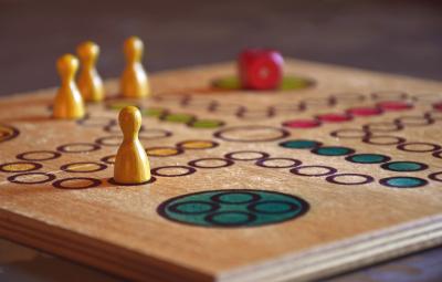 Close up photo of a board game with wooden game pieces 