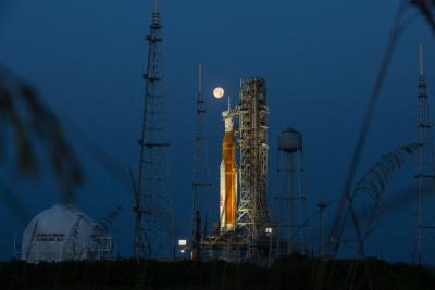 A full Moon is in view from Launch Complex 39B at NASA’s Kennedy Space Center in Florida on June 14, 2022. The Artemis I Space Launch System (SLS) and Orion spacecraft, atop the mobile launcher, are being prepared for a wet dress rehearsal to practice timelines and procedures for launch. The first in an increasingly complex series of missions, Artemis I will test SLS and Orion as an integrated system prior to crewed flights to the Moon. Through Artemis, NASA will land the first woman and first person of col