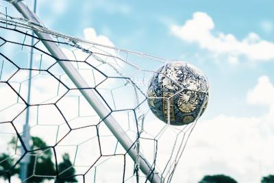 Photo of a soccer ball hitting the goal net.