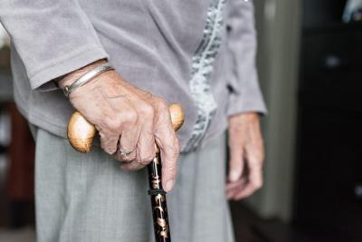 Close up photo of an elderly woman's hands holding a cane