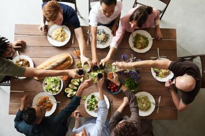 Group of friends eating dinner, toasting, shot from above.