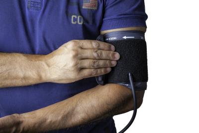 Photo of a man's arm wearing a blood pressure cuff. 