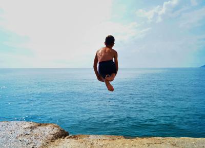 Child jumping off into ocean