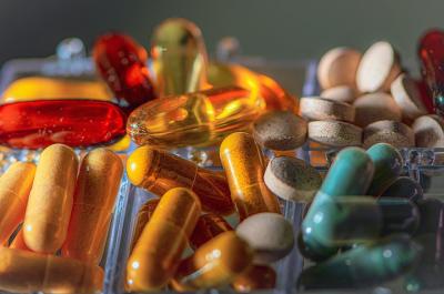 A close up photo of pills, vitamins and medications in multiple colors. 