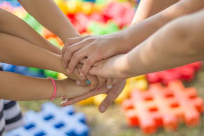 Photo of a group of people piling hands in a show of sportsmanship