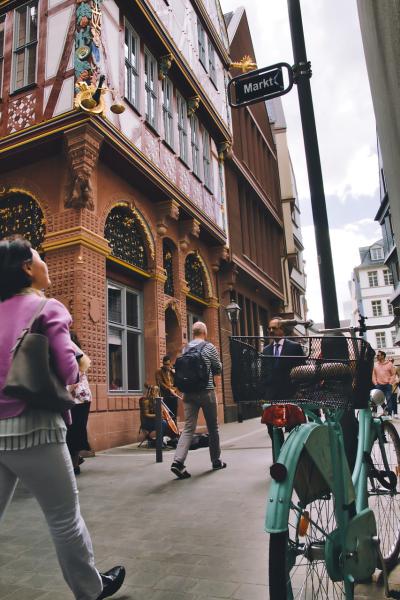 Photo of people walking down a street dressed for work to represent an outdoor commute.