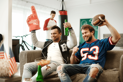 Football fans cheering in their living room. 