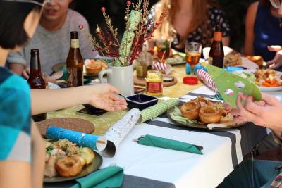 Photo of a dining table with plates / food and Christmas favors, showing friends gathered to party. 