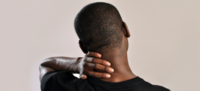 A man rubs his neck while feeling the weight of anxiety.