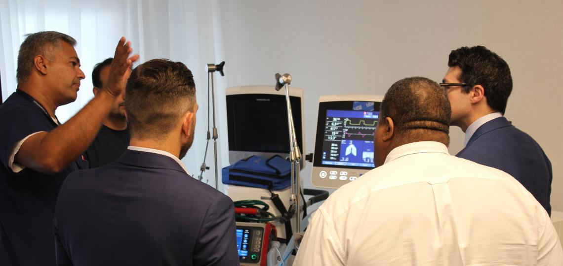Advances In Critical Care Several people observe a demonstration of a surgical tool.