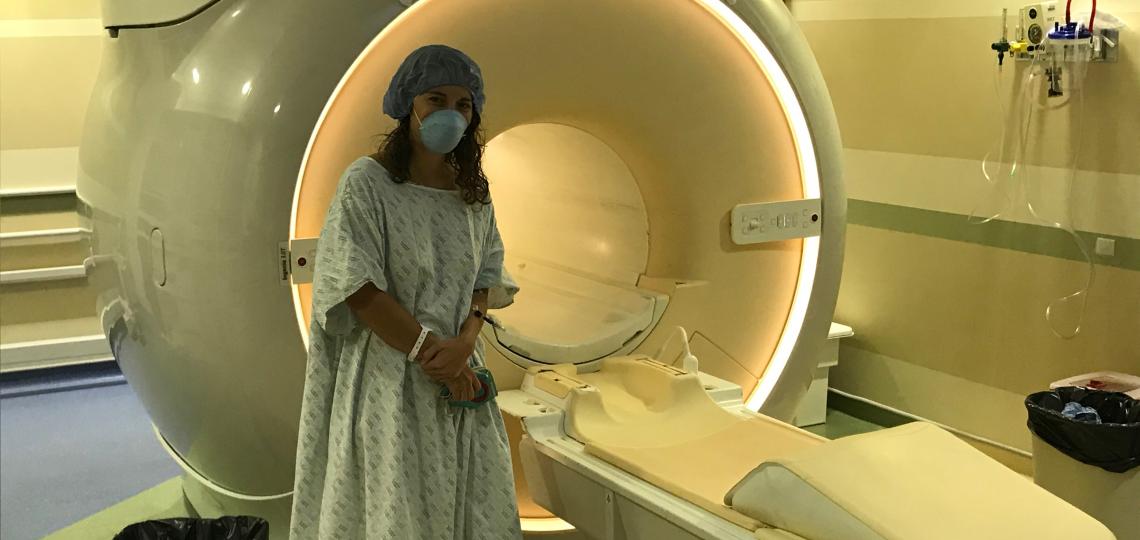 A woman standing in front of a CT machine.