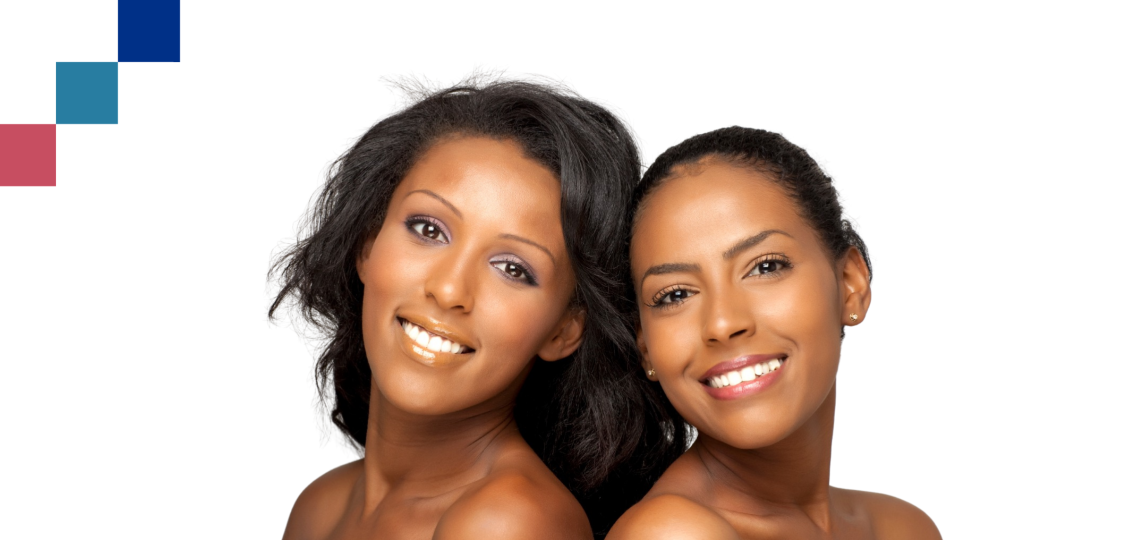 Two women with glowing skin posed back to back and smiling.