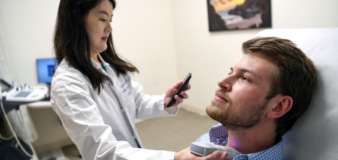 Doctor performing ultrasound on a patient's neck.