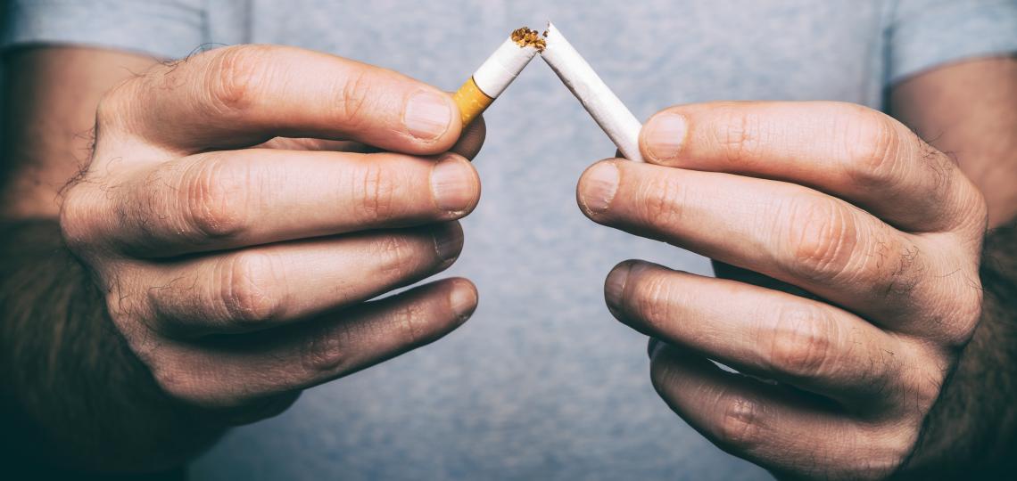 A man holding a cigarette broken in half.